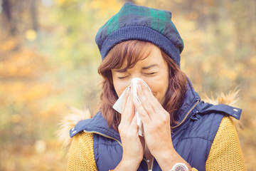Junge Frau hat Schnupfen im Herbst