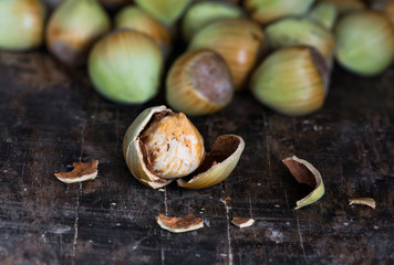 Fresh cobnuts and a cracked nut on vintage wooden background