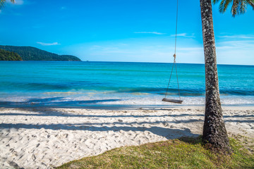 Swing on beautiful tropical island beach in sunny day blue sky background. Summer tropical travel holiday vacation or green nature concept.