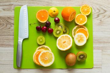 Fresh citrus cut on a board on a white wooden table . View from
