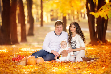 happy young family spending time outdoor in the autumn park