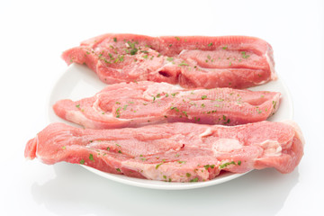 several steaks raw turkey on white