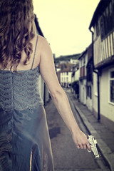 woman in gown with handgun on street