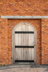 Wooden door on orange brick wall.