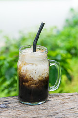 Iced black coffee with fresh milk in jug, jar, mug glass cups on the table