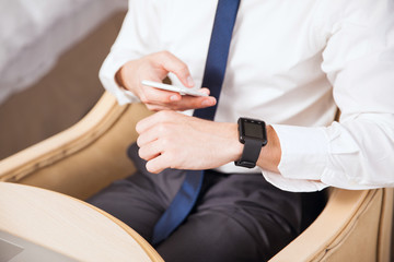 Fototapeta premium Businessman syncing smart watch to his phone