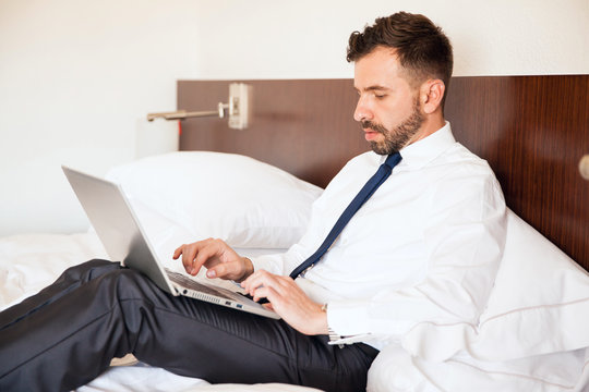 Businessman working on a hotel bed