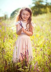 The girl in the peach dress in the meadow with wildflowers.