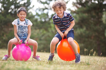 Fototapeta na wymiar Junge und Mädchen auf einem Hüpfball