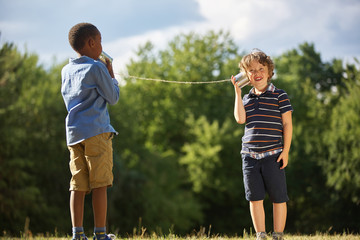 Zwei Jungen spielen mit Dosentelefon