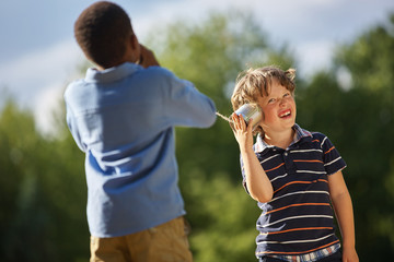 Zwei Jungen spielen mit Dosentelefon