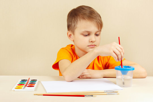 Young artist in an orange shirt going to paint colors