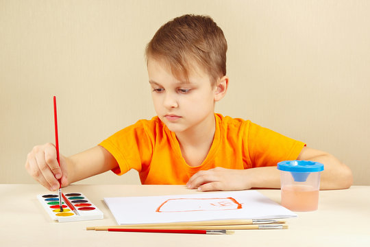 Young artist in an orange shirt painting colors
