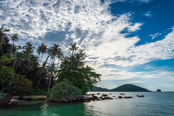 Obraz premium Beautiful tropical island beach in sunny day blue sky background. Summer tropical travel holiday vacation or green nature concept.