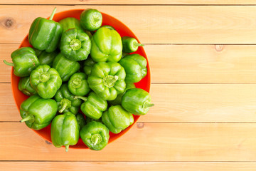 Overhead view of large red bowl filled peppers