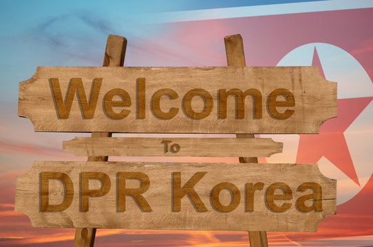 Welcome to DPR Korea sing on wood background with blending national flag