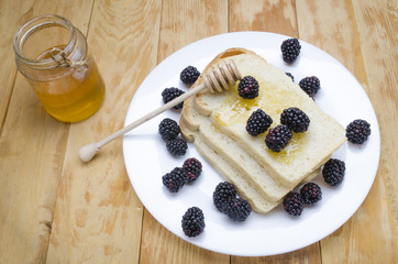 honey with a stick and blackberry