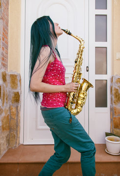 Chica joven tocando el saxof&oacute;n