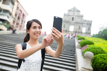 Woman taking selfie by mobile phone in Macao