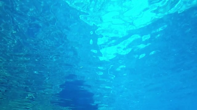 Underwater scene with glittering and moving surface. Abstract footage from a swimming pool.