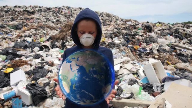Woman in Mask Holding Hologram Planet Earth at Landfill Site