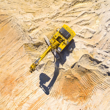 Aerial view of a working excavator in the mine. Industrial background on mining theme. 