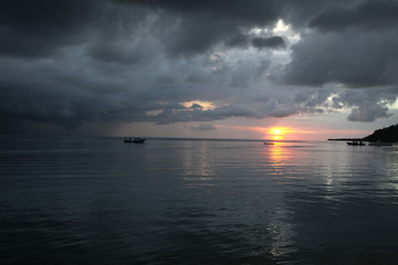 beautiful asian cloudy sunset over the ocean with boat silhouettes