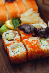 Beautiful Chinese food and sushi rolls on wooden background
