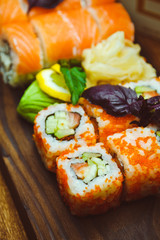 Beautiful Chinese food and sushi rolls on wooden background