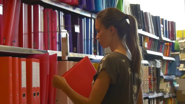 College student chooses folder in stationery