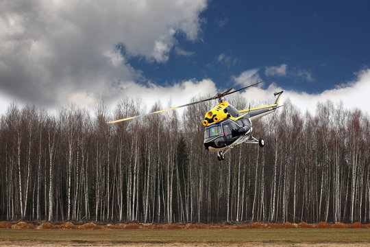 Aircraft - Black-yellow helicopter makes flight at low height