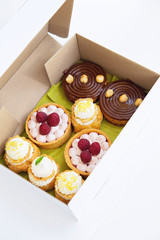 Assorted fresh desserts in the white paper box.  - 118757943