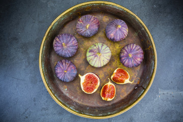 Fototapeta na wymiar Ripe figs in the old bowl on a stone background.