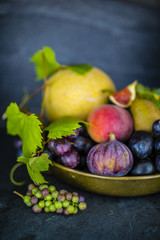 Beautiful still life with grapes and figs and other fruits on stone background.
