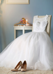 Fototapeta na wymiar Shoes and wedding dress on chair in room