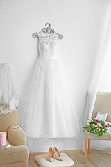 Beautiful wedding dress on hanger in room