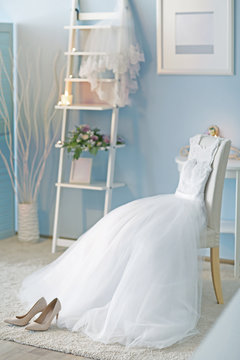 Shoes And Wedding Dress On Chair In Room