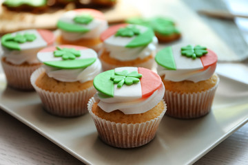 Tasty cupcakes with clover on plate. Saint Patrics Day concept