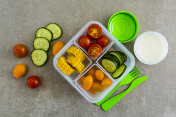 Healthy vegetarian food in plastic lunch box on light background.
