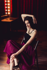 woman in skirt sitting on chair indoor shot