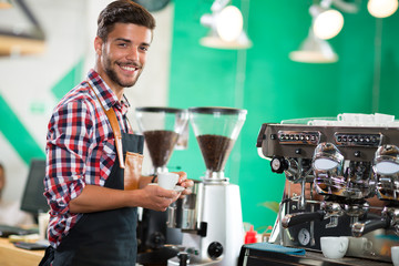 Waiter holding cup of coffee at the cafe
