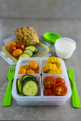 Healthy vegetarian food in plastic lunch box on light background.
