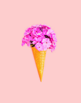 Ice cream cone with flowers over colorful pink background top vi