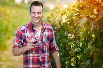 Naklejka na ściany i meble man smiling and holding glass of wine