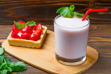 Strawberry ice cream with a cup of yogurt on a wooden background