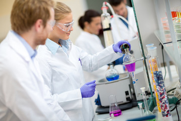 Fototapeta na wymiar Female chemical technician mixing fluids in laboratory