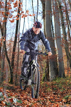 Senior auf dem E-Mountainbike im Wald