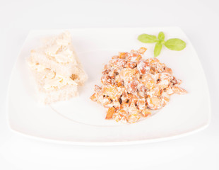 Sauteed chanterelle with cream and garlic and some white bread on a plate decorated with basil