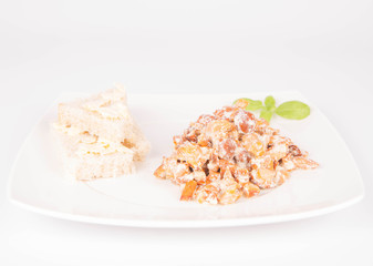 Sauteed chanterelle with cream and garlic and some white bread on a plate decorated with basil