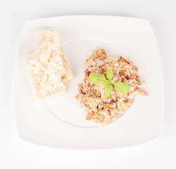 Sauteed chanterelle with cream and garlic and some white bread on a plate decorated with basil